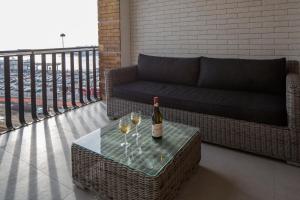 a couch and wine glasses on a table on a balcony at Relais Castel Nuovo in Naples