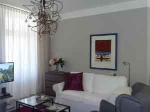ein Wohnzimmer mit einem weißen Sofa und einem Kronleuchter in der Unterkunft Appartement Fischersfritze in Göhren