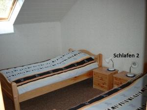 a bedroom with a bed and a table and a window at Ferienwohnung Bäumener in Hilchenbach