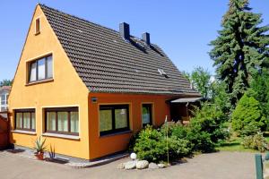 オストゼーバート・ゼリンにあるSelliner Ferienwohnungenの黒屋根の黄色い家