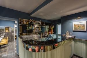 un bar con barra y una estantería de alcohol en Otivm Hotel en Roma