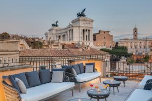 a balcony with couches and tables and a view of the city at Otivm Hotel in Rome