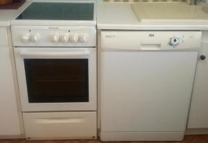 a kitchen with a white stove and a refrigerator at Location-Meublé in Issenheim