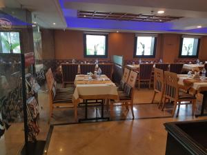 a restaurant with tables and chairs in a room at The Classik Fort in Cochin