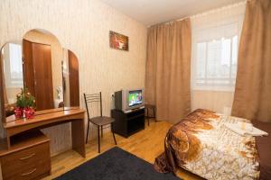 モスクワにある2-х комнатные апартаменты Ельのベッドとテレビが備わるホテルルームです。