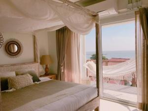 1 dormitorio con cama con dosel y balcón en Villa S, en Hua Hin