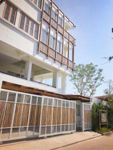 una gran casa blanca con una valla de madera en Villa S, en Hua Hin