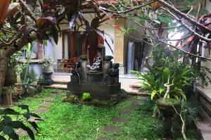 a garden in front of a house with plants at Bagus Homestay in Ubud