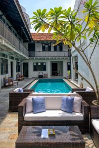 a pool with a couch in front of a building at Noordin Mews in George Town