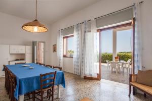 サン・フォカにあるVilla Mare di Puglia m552のダイニングルーム(青いテーブル付)、パティオ付きの部屋