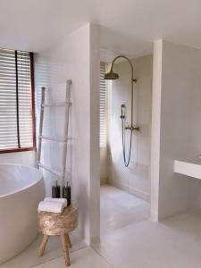 a white bathroom with a tub and a shower at Villa S in Hua Hin