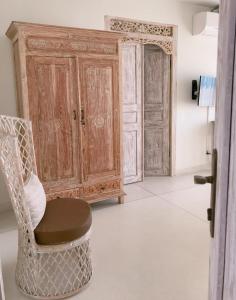 een kamer met een stoel en een houten kast bij Villa S in Hua Hin