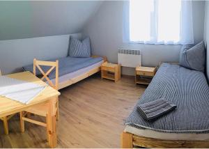 RościnoにあるHostel Przystanのベッド1台とテーブル2台が備わる小さな客室です。