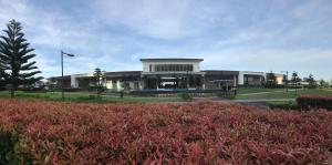 een gebouw met veel rode planten ervoor bij JJ Suites Tagaytay @ Wind Residences in Tagaytay