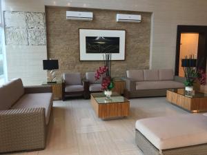 JJ Suites Tagaytay @ Wind Residences في تاجيتاي: غرفة معيشة بها كنب وكراسي وطاولة
