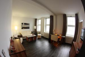 a living room with a couch and a table at Hotel Goldene Krone in Clausthal-Zellerfeld