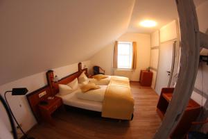 ein Schlafzimmer mit einem großen Bett im Dachgeschoss in der Unterkunft Hotel Goldene Krone in Clausthal-Zellerfeld