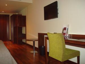 - un salon avec une table et une chaise verte dans l'établissement Palace Hotel & Spa Termas de São Tiago, à Penamacor