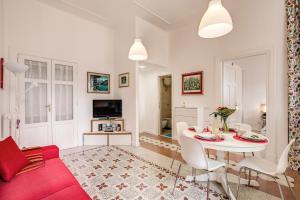 sala de estar con mesa blanca y sofá rojo en La casa di Nonna Pina, en Roma
