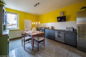 eine Küche mit einem Tisch und eine Küche mit gelben Wänden in der Unterkunft Hürth-Efferen1 in Hürth