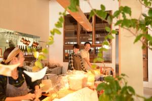 a group of people standing in a kitchen preparing food at Taketa Ekimae Hostel cue in Taketa