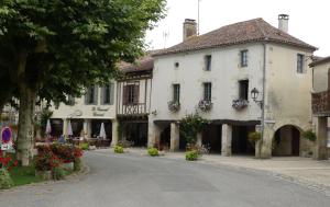 a large white building with flowers in front of a street at Les Hirondelles in Fourcès +18 photos
