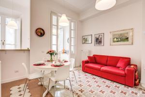 a living room with a red couch and a table at La casa di Nonna Pina in Rome