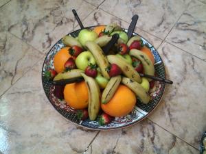 a bowl of fruit with bananas and oranges on a counter at Azur Tafraout in Tafraoute