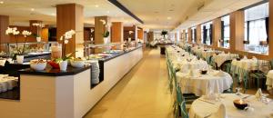 Hotel Guitart Central Park Aqua Resort في يوريت دي مار: مطعم بطاولات بيضاء وكراسي وطاولة