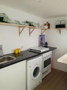 a kitchen with a washing machine and a sink at Casa da Madrinha I in Monte Gordo