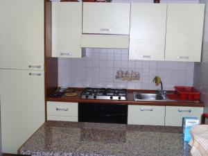 een keuken met witte kasten, een fornuis en een wastafel bij Casa Lieta in Subiaco