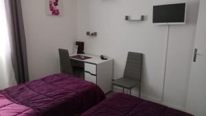 a bedroom with a desk and a bed and a desk and chair at Hôtel Montespan in Lussac-les-Châteaux