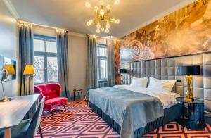 a hotel room with a bed and a red chair at Grand Poet Hotel and SPA by Semarah in Rīga