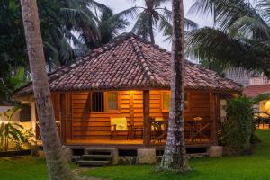 a cabin in the middle of palm trees at Rockside Cabanas Hotel in Unawatuna