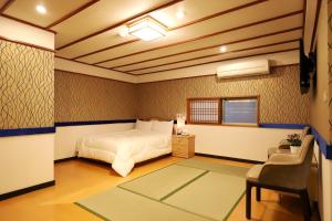 a bedroom with a bed and a chair and a window at Gorgeous Hot Spring Resort in Taipei