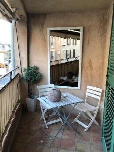 una mesa y sillas en un balcón con espejo en Perrine Duplex, en Saint-Tropez