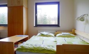 a bedroom with two beds and a desk and a window at Apartman Mariana in Nový Smokovec