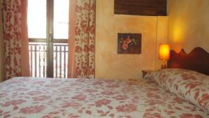 sypialnia z dużym łóżkiem i oknem w obiekcie Residence Les Lacs w mieście Bardonecchia