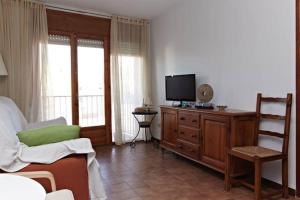 a living room with a tv on a wooden dresser at Apartamento Pau Casals in L'Ametlla de Mar