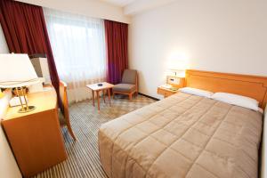 a hotel room with a bed and a chair at Navios Yokohama in Yokohama