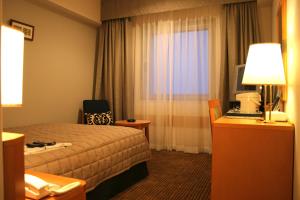 Habitación de hotel con cama y ventana en Navios Yokohama en Yokohama
