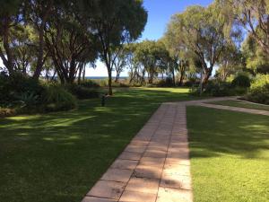 una pasarela en un parque con árboles y césped en Geographe Bay Apartment, en Busselton