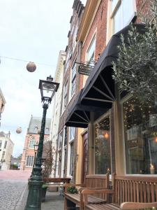 una luz de la calle frente a una tienda con bancos en ExLibris Boutique Hotel en Leiden