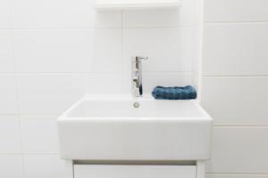 a white bathroom sink with a blue towel on it at d.Five Stylish Studio at Parliament in Budapest