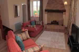 a living room with two red couches and a fireplace at La Bucherie in Montembœuf