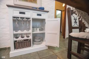 un armario blanco con platos y platos. en Alborada Dayman, en Termas del Daymán