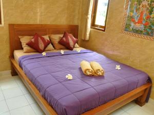 una cama con dos almohadas encima en Mira Family Homestay, en Ubud