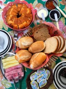 a table topped with lots of different types of bread at Pousada Tia Cleide in Caraguatatuba