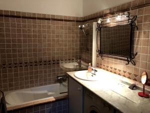 La salle de bains est pourvue d'un lavabo, d'une baignoire et d'un miroir. dans l'établissement Perrine Duplex, à Saint-Tropez