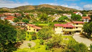 un pueblo con casas y montañas en el fondo en La Vida es Bella en Samaipata